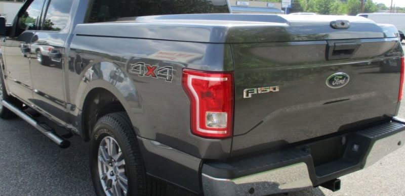 A hard tonneau cover on a Ford F150 model pickup truck