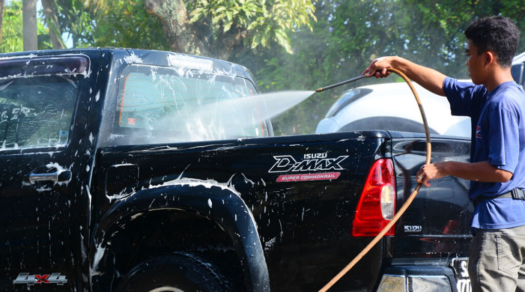 View of a man doing a car wash on a pick up truck